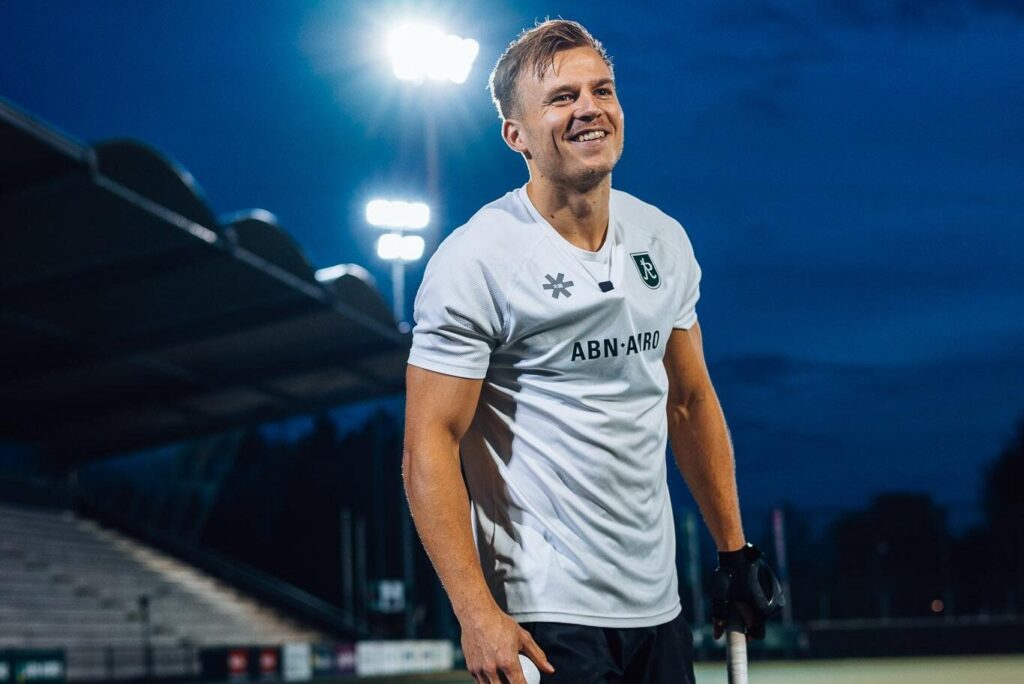Thijs van Dam lacht op het hockeyveld tijdens de avondtraining.