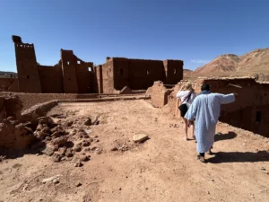 Lokale gids begeleidt toerist over kasbah-muur in Marokko tijdens leiderschapsreis
