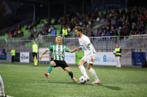 Jelle van der Heyden in actie tijdens een voetbalwedstrijd, met de bal aan zijn voet en focus in zijn blik.